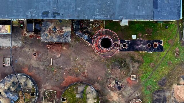 Aerial view of industrial ruins with a central chimney and weathered structures in Jelgava, Latvia.