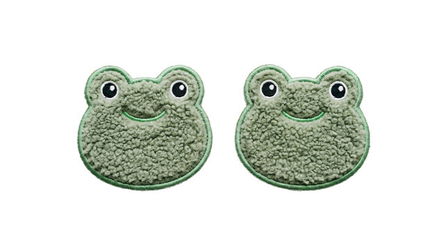 Two cute green plush frog faces with soft fuzzy textures and detailed embroidered outlines isolated for sewing projects on transparent background