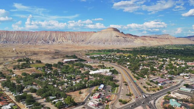 Aerial drone view of cars i70 Book Cliffs Mesa Clifton Colorado River Downtown Grand Junction tower Colorado afternoon clouds summer sunny blue sky Grand Mesa Parachute Fruita Mt Garfield forward pan
