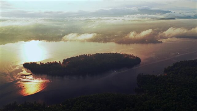 Two jet skis Lake Schroon Clarks Island ummer golden hour sunset mist low clouds aerial drone harbor view Up State New York landscape Town of Schroon Lake Pharaoh Mtn Adirondack Mountains circle left