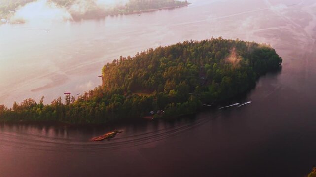Jet skis ride Lake Schroon Clarks Island ummer golden hour sunset mist low clouds aerial drone harbor view Up State New York landscape Town of Schroon Lake Pharaoh Mtn Adirondack Mountains parallax