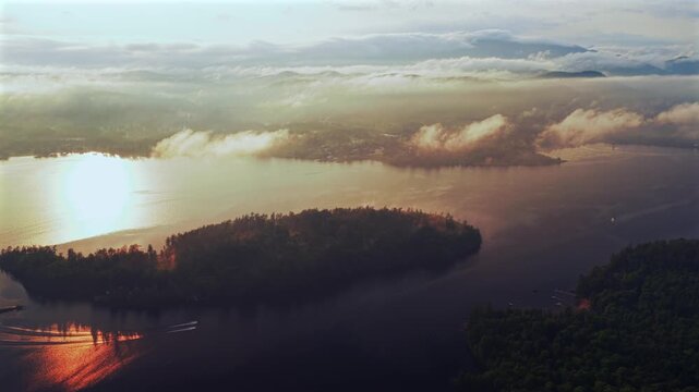 Two jet skis Lake Schroon Clarks Island ummer golden hour sunset mist low clouds aerial drone harbor view Up State New York landscape Town of Schroon Lake Pharaoh Mtn Adirondack Mountains backwards
