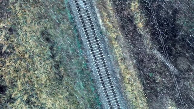 Aerial view of railway tracks cutting through the grassy landscape in Jelgava, Latvia.