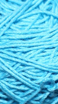 A ball of blue yarn sitting on a table, ready for knitting or crafting. Rotating in a circle