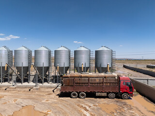 red truck parked next to grain silos © zhu difeng