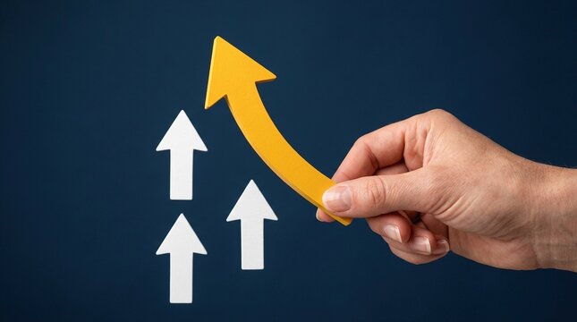 Hand holds a large yellow curved arrow, pointing upwards, positioned against smaller white arrows on a dark blue background, symbolizing leadership, innovation, and successful business growth.
