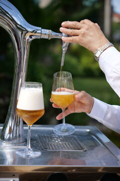 Mano sirviendo cerveza de un grifo en una copa