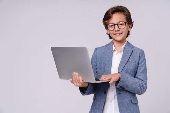 Smart little boy with laptop in formal clothes isolated on grey background, childhood, technology, education, future businessman, digital learning, career and professional concept