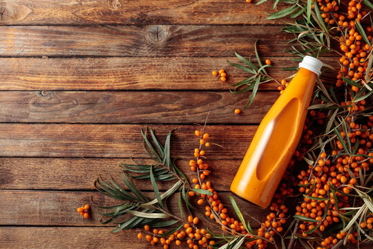 Bottle of sea buckthorn juice with fresh berries.