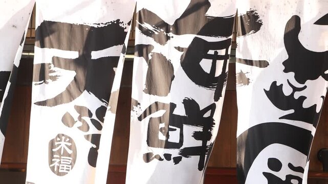 Rows of decorative sake barrels covered in bold Japanese calligraphy create a graphic cultural detail in Kyoto&rsquo;s historic Gion area, evoking Shinto traditions and local brewing heritage