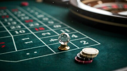 Obraz premium Elegant roulette game setup with glass ball and poker chips on green casino table