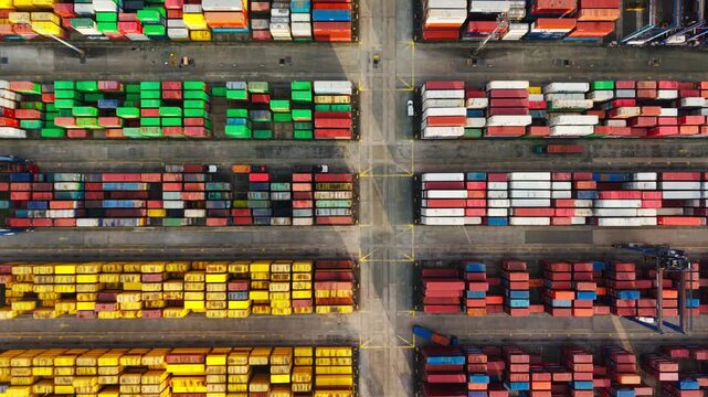 Top down aerial reveals colorful cargo rows as the drone glides at sunset