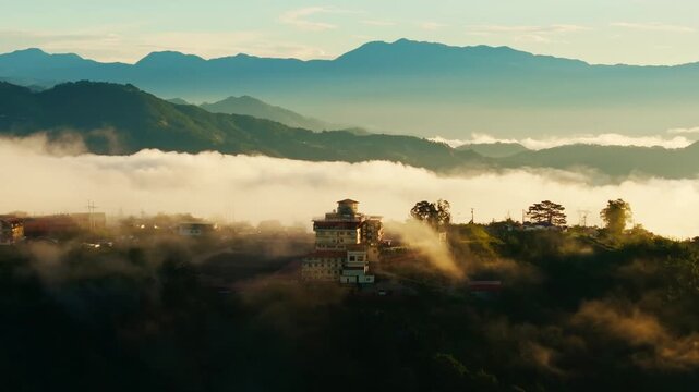 Warm dawn light reveals layered blue peaks beyond a misty Benguet valley