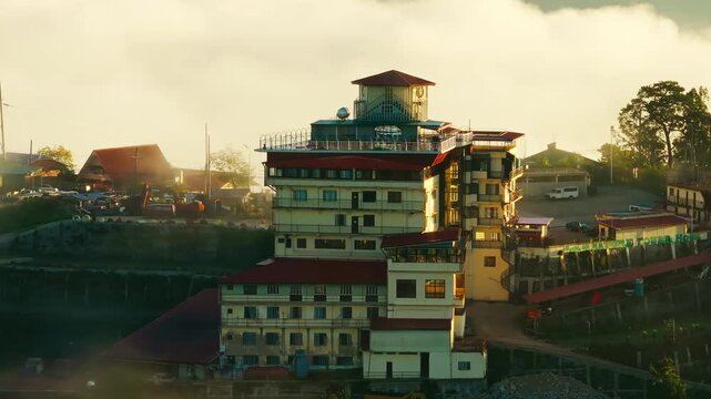 Warm sunrise reveals a large mountain hotel overlooking rural Benguet hills