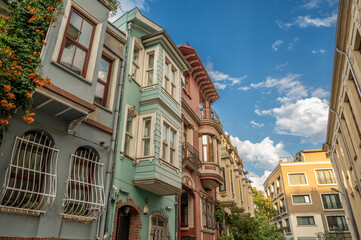 Obraz premium Istanbul,turkey,august 2, 2025. Colorful historic houses lining a street in balat, istanbul, turkey, displaying traditional architecture under a blue sky