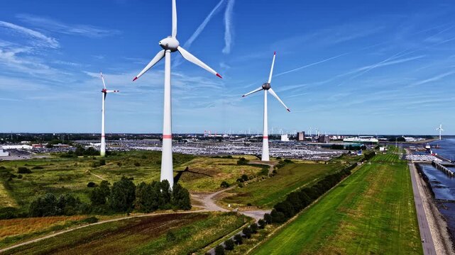 Wind turbines producing renewable energy near the Emden in Germany in aerial establishing view