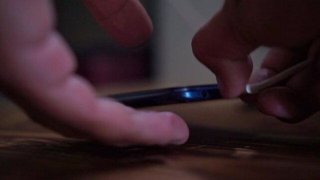 hands releasing charger cable from phone port, charging device, mobile technology concept footage scene.
