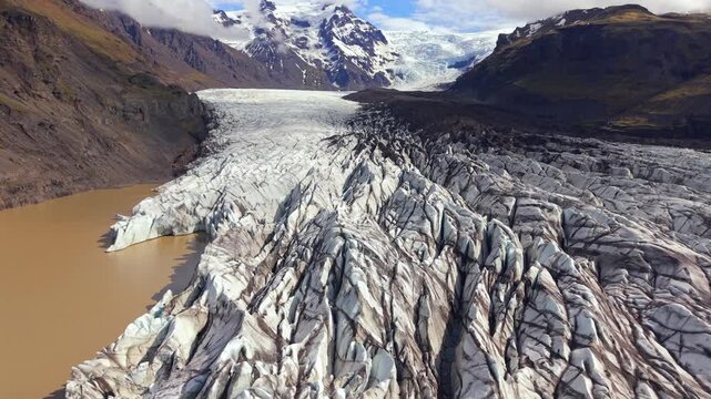 Stunning aerial footage flying above the vast Svinafellsjokull glacier tongue, showing its majestic ice formations and glacial lake
