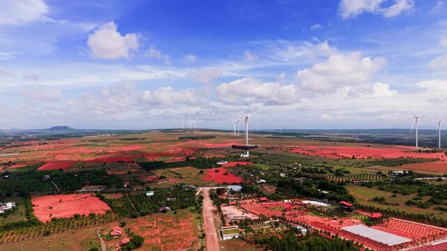 Views of Hoa Thang in Lam Dong show wind turbines in the distance. The land is open with fields and roads visible. The sky is bright with clouds. This place offers a clear look at nature and land use.