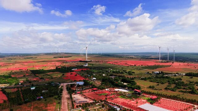 The landscape of Hoa Thang in Lam Dong. The views include fields, wind turbines, and the sky. The weather appears bright and the land stretches far.