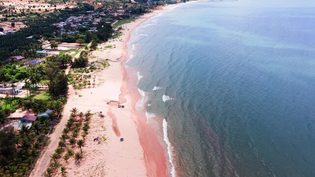 People gather at the beach in Hoa Thang, Lam Dong. They enjoy the sun and the sea along with the beautiful landscape. The coastline offers stunning views of the mountains and sky.