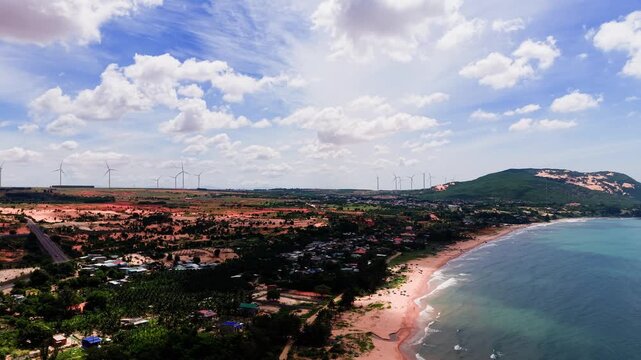 This captures aerial views of Hoa Thang in Lam Dong. The time is during the day, and you can see the beach, hills, and blue sky. It shows the diverse scenery in this area.