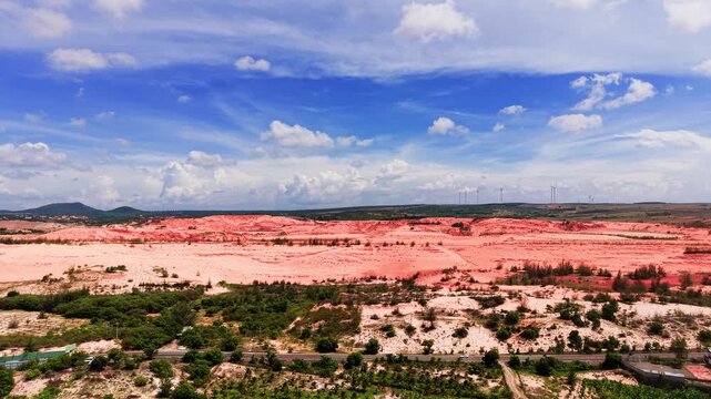 The viewer looks over the lands of Hoa Thang in Lam Dong. Red soil and green patches stand out under the blue sky. It is a bright day, perfect for enjoying nature.