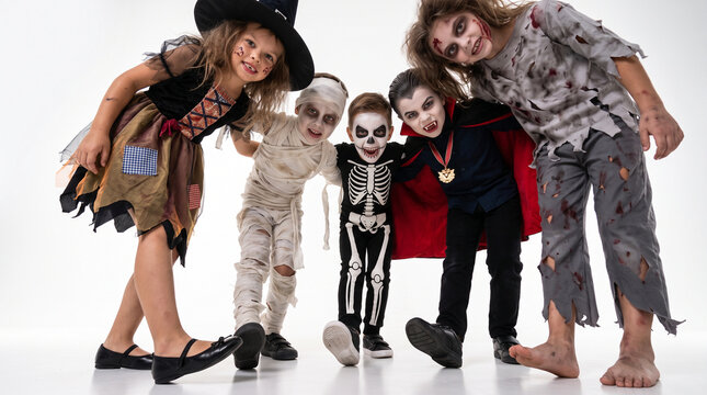 Group of children dressed as witch, mummy, skeleton, vampire and zombie running toward the camera with playful scary expressions on a white background, Halloween costumes, trick or treat, monster part