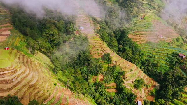 Aerial left turn emerges between clouds reveals terraced farms across highlands