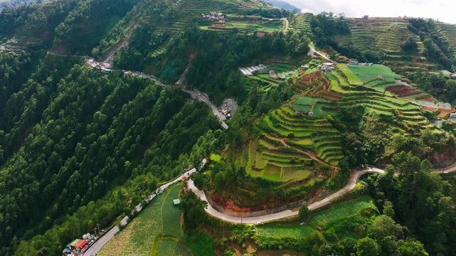 Rising aerial turn reveals winding roads and mountain terraces in Atok, Benguet