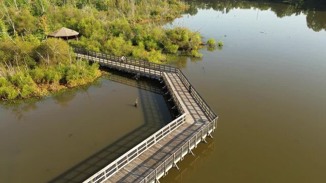 Aerial shot of a man bicycling along the Raleigh, NC greenway nature trail over Crabtree Creek