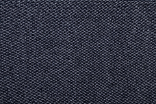 Texture of dark navy blue knitted wool fabric background. Woven tweed or jersey textile surface