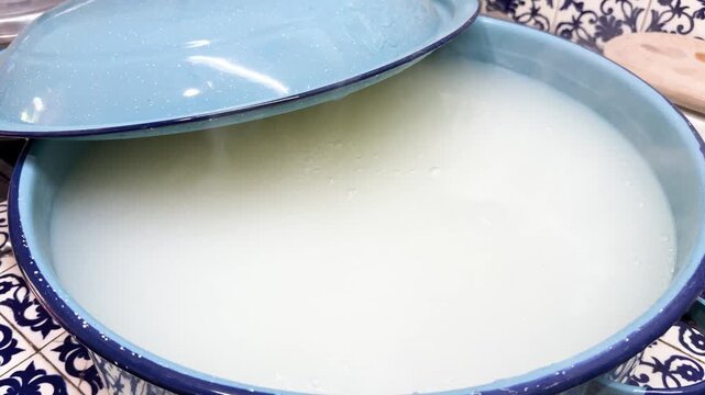Traditional atole simmers in blue pot on patterned kitchen counter, close up
