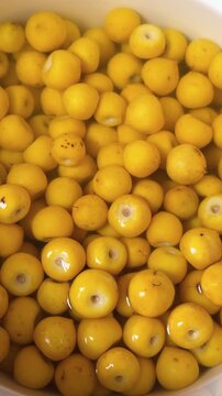 Fresh nance fruits soaking in bowl of clean water, ready for preparation