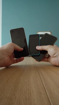 Point of view of hands holding several old and unused smartphones, representing electronic waste, device replacement, recycling and outdated technology.