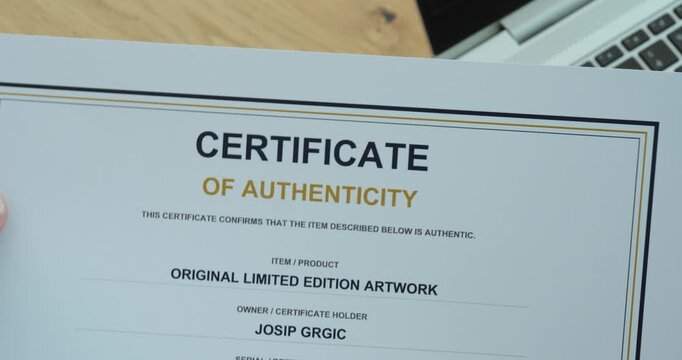 Close-up of a person pointing at a certificate of authenticity, representing verification, proof of originality, genuine products and authenticity documentation.
