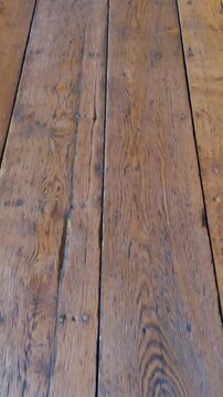 Aston Hall oak floorboards seen from a low forward walking camera, revealing worn timber planks and patina inside the Jacobean manor house in Birmingham, England. Vertical format.