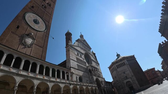 Torrazzo, Cremona Cathedral and Baptistery frame Piazza del Comune with Romanesque Gothic architecture, arcaded porticos and historic facades, Cremona, Lombardy, Italy, static upward shot