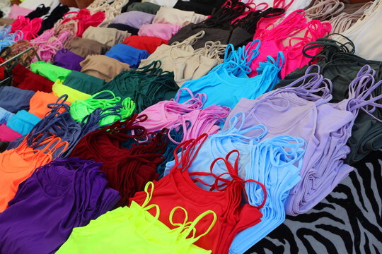 Colorful tank tops and camisoles displayed on a market stall