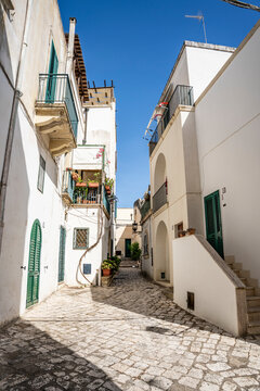 Picturesque street in the historic center of Otranto, with traditional buildings and a relaxed atmosphere reflecting the slow pace of life, Otranto, Salento, Puglia, Italy.