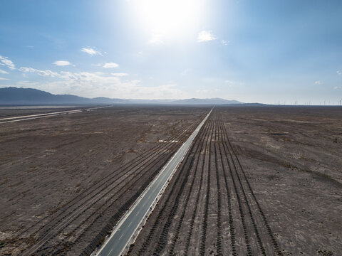 straight road extending into the distance in the desert wilderness under blue sky