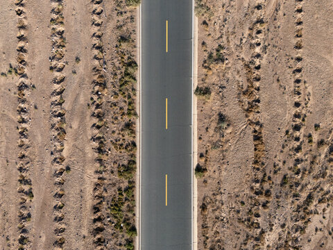 aerial view of a straight road cutting through the desert landscape