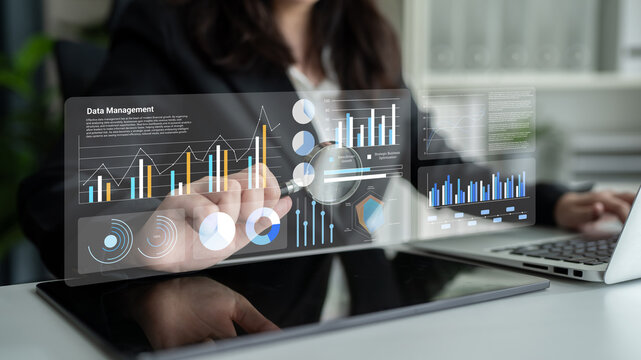 A business professional engages with a transparent touchscreen displaying important data analysis and management tools in a modern office setting. Gantry