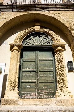 Weathered carparo stone portal on a historic building in the old town of Otranto, showing the effects of wind and time, Otranto, Salento, Puglia, Italy.