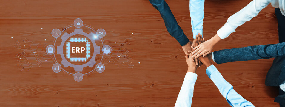 A diverse group of professionals collaborates on business strategies for ERP integration. Hands unite above a table, symbolizing teamwork and innovation in a digital age. Trope