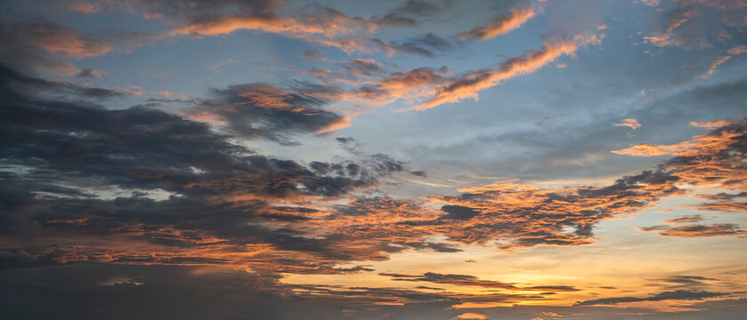 Panoramic Sunset Sky with Golden Orange Clouds and Soft Blue Sky.