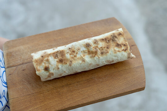 Shawarma sandwich gyro fresh roll of lavash chicken beef shawarma falafel with oven-cooked or cooked on stove meat, mushrooms, cheese. Concept of traditional middle eastern food on wooden background.