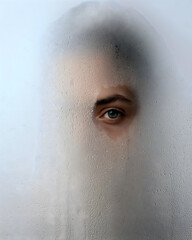 Fototapeta premium Human Eye Looking Through Frosted Glass Surface