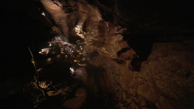 Exploring dark underground cavern with artificial lighting