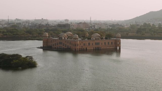 Aerial view of jal mahal water palace on man sagar lake in jaipur, india with the city skyline in the background